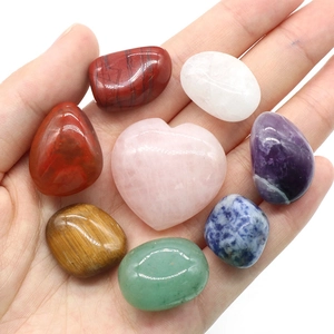 7 Chakra irregular polished stones set with one pink crystal heart held in hand