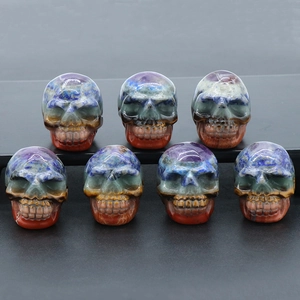 Set of seven natural crystal skull carvings with colorful striped stone patterns and polished finish