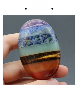 Detailed view of hand-held oval 7-chakra energy stone with multi-layer natural minerals