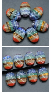Detailed view of polished oval seven chakra healing stones with colorful layered textures