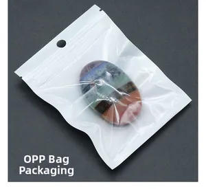 Close-up of a polished oval chakra stone in multi-color layers inside an OPP bag