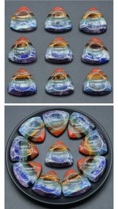 Primo piano di pietre chakra triangolari levigate con sette strati di cristalli colorati