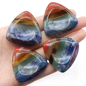 Quattro pietre curative a sette chakra triangolari con strati di cristalli colorati