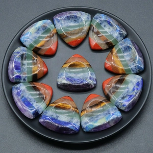 Set di 10 pietre chakra triangolari con strati di cristallo colorati in un vassoio nero