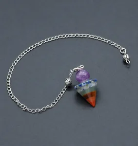 Macro detail of seven chakra natural crystal pendulum with conical stones and silver chain