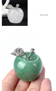 Macro shot of 30mm natural clear quartz crystal apple with silver rhinestone leaf detail