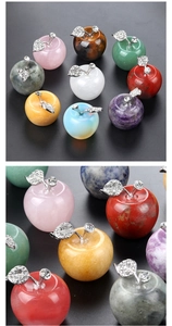 Macro view of natural crystal stones carved as apples with rhinestone leaf accents