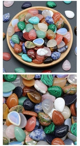 Macro shot of assorted colorful teardrop-shaped natural crystal and gemstone cabochons