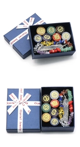Makroansicht Chakra-Steine Set mit Kristallanhänger und Armband in einer blauen Geschenkbox