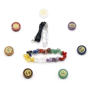 7 Chakra Stein Set mit Kristallarmband und Anhänger auf weißem Hintergrund