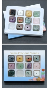 Macro view of 12-piece square semi-precious stone beads in clear display packaging
