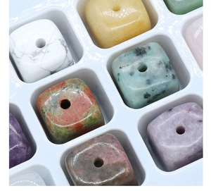Detailed view of polished square natural stone beads with central holes in various minerals