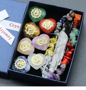 Detalle de siete piedras chakra con forma de corazón y colgante de cristal en caja azulada