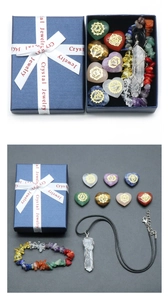Detalle de piedras de chakra en corazón y collar de cristal en caja de regalo azul