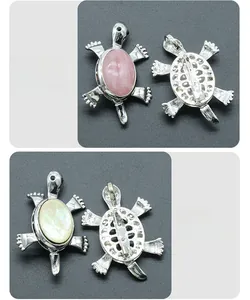 Dettaglio di spille a forma di tartaruga in quarzo rosa e conchiglia bianca placcate argento