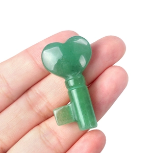 Natural green aventurine crystal key carving with heart top held by a hand