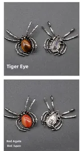 Macro view of spider brooches featuring Tiger Eye and Red Agate stones in silver metal