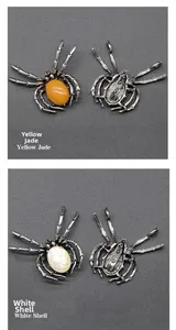 Macro detail of spider brooch pendant showing yellow topaz, white shell, and silver frame