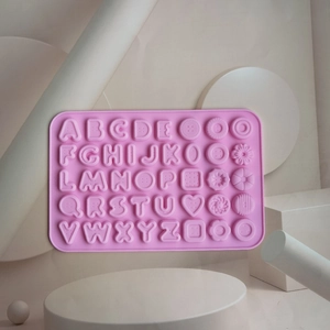 Close-up of pink silicone alphabet and flower shaped mold for baking and chocolate DIY