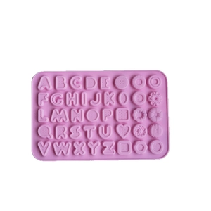 Pink silicone alphabet and flower mold for chocolate and cake baking on white background