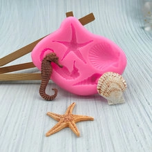 Macro detail of pink silicone mold with 3D starfish and seahorse fondant shapes
