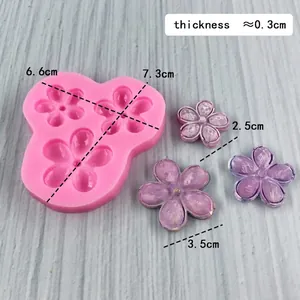 Pink silicone mold for 3D flowers with purple resin finished product samples on wood