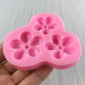 Pink silicone mold featuring three cherry blossom shapes for fondant and cake baking