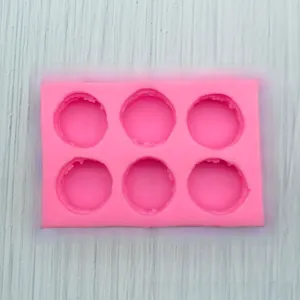Macro detail of flexible pink silicone mold with 6 cavities for macarons and baking