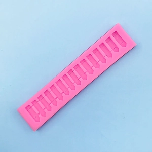 Detailed macro view of pink silicone mold featuring 12 fence shaped slots for DIY baking