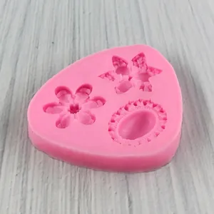 Pink silicone flower mold for fondant and chocolate on a white wood background