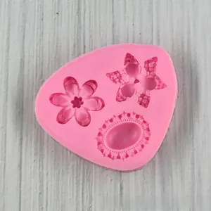Pink silicone mold featuring two flower shapes and an oval relief for fondant crafts