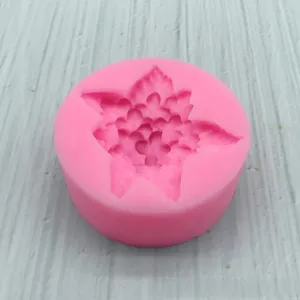 Macro detail of round pink silicone mold featuring intricate multi-petal flower carving