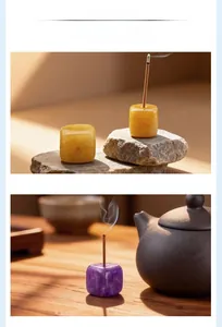 Close-up of square natural crystal incense burners in amber and purple stone finishes