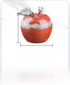 Detail of red stone apple ornament with silver metal leaf and white crystal accents