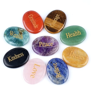 Nine piece set of oval natural crystal stones with engraved golden inspirational words