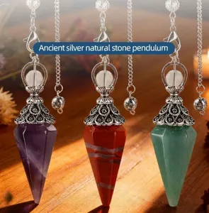 Three natural stone dowsing pendulums with antique silver flower caps on wooden surface