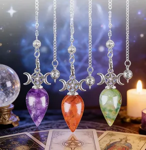 Close-up of triple moon crystal pendulums on a starry background with mystic tarot cards