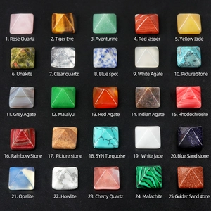 Collection of 25 crystal pyramid gemstones in varied materials on black background