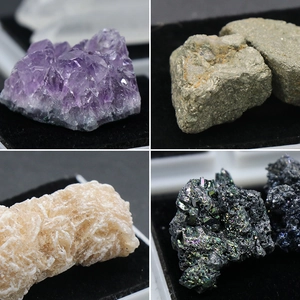 Variety of natural mineral specimens including amethyst and desert rose on black display pads