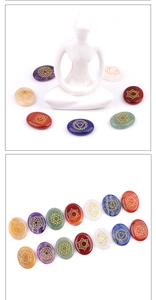 Close-up of seven chakra natural stones with golden engraved symbols for meditation