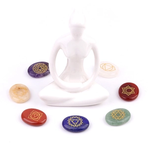 Seven chakra healing crystal stones set with gold symbols and meditation statue