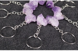 Detailed close-up of natural purple raw amethyst stone keychains with silver metal rings