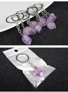 Detail of natural raw amethyst stone keychain with silver metal ring in packaging