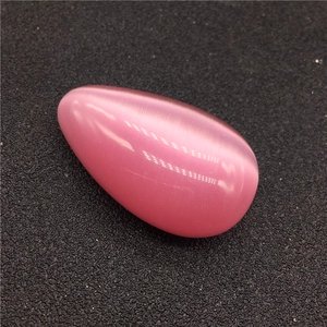 Dettaglio di una pietra occhio di gatto rosa a goccia con superficie lucida e gatteggiamento