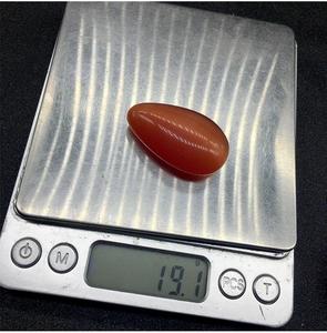 Bilancia digitale che mostra il peso di 19,1g di un ciondolo in cristallo rosso goccia