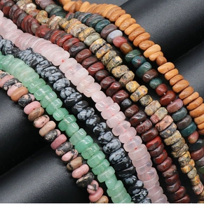 Macro shot of assorted natural crystal disc beads for DIY jewelry making on black display