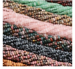 Macro shot of mixed natural crystal abacus beads including aventurine and pink quartz