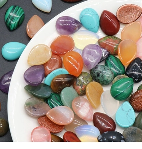 Primer plano de piedras de cristal en forma de gota pulidas en varios colores