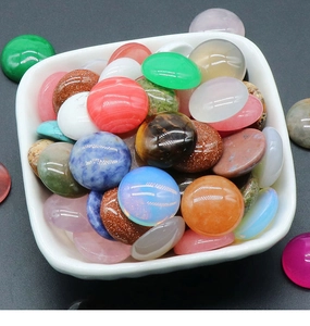 Close-up of mixed natural stone cabochons in a white bowl showing vibrant colors and textures