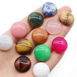 Polished 18mm round natural crystal gemstone cabochons displayed on a palm for DIY jewelry
